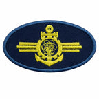 Emblema oval bordado azul-escuro com âncora amarela central, círculo acima e barras horizontais