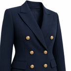 Blazer azul-marinho de lapelas pontudas, fechamento duplo, quatro botões dourados e bolsos frontais