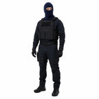 Homem em traje tático negro usando balaclava, colete e arma na cintura