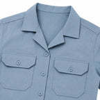Camisa azul clara com bolsos frontais com abas e mangas curtas.