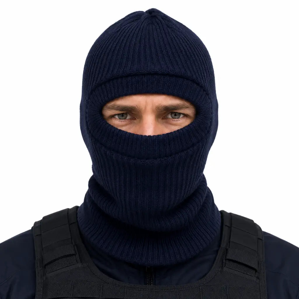 Indivíduo com balaclava azul-escuro de malha e colete tático, olhos visíveis