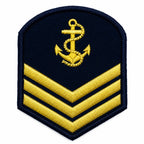Emblema de patente em escudo azul com âncora dourada e duas faixas diagonais