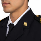 Close-up de gola e lapela em uniforme escuro com insígnias douradas