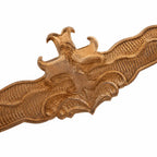 Distintivo dourado alongado com cruz central e detalhes ornamentais
