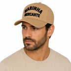 Homem usando boné bege Marinha Mercante com inscrição frontal em letras escuras