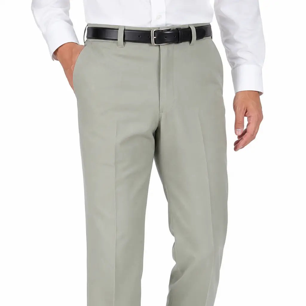 Homem com camisa branca de botão, calça cinza clara com pregas, cinto preto.