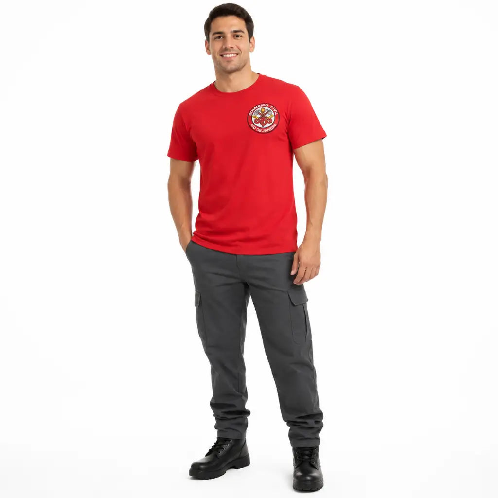 Homem sorridente com Camiseta Vermelha Bombeiro Civil RJ, calça cargo cinza e botas pretas