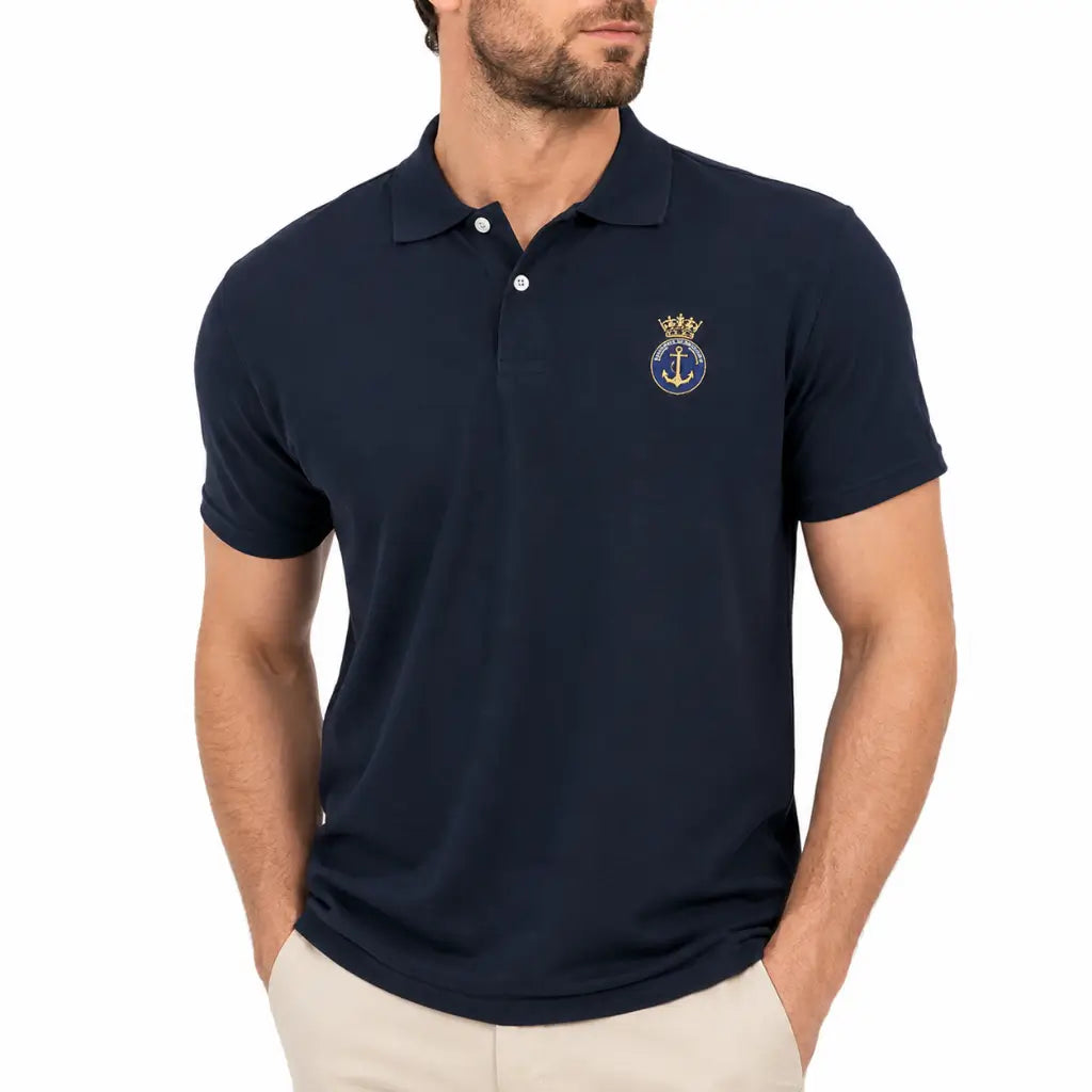 Homem com camisa polo azul marinha bordada com âncora em círculo e coroa