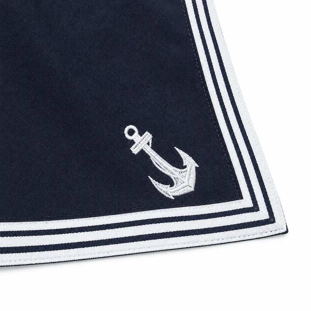 Peça de tecido azul-marinho com borda listrada e âncora branca no canto inferior esquerdo