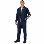 Homem veste conjunto esportivo azul marinho com jaqueta de zíper e listras brancas.