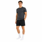 Jovem posando com meias brancas, fundo branco, look casual esportivo