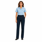 Mulher em uniforme profissional, camisa azul clara e calças retas escuras