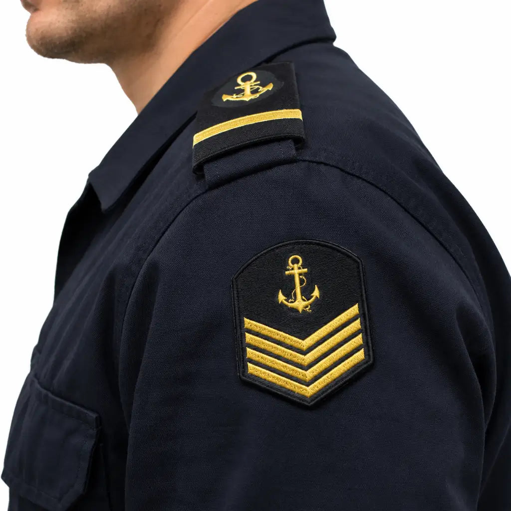 Close-up de uniforme naval azul-marinho com âncora amarela e insígnias no ombro e braço