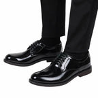 Par de sapatos sociais pretos brilhantes com cadarços, vistos de lado