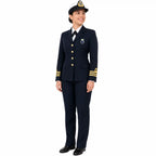 Mulher em uniforme azul-marinho, gravata preta, boné branco, sorrindo confiante