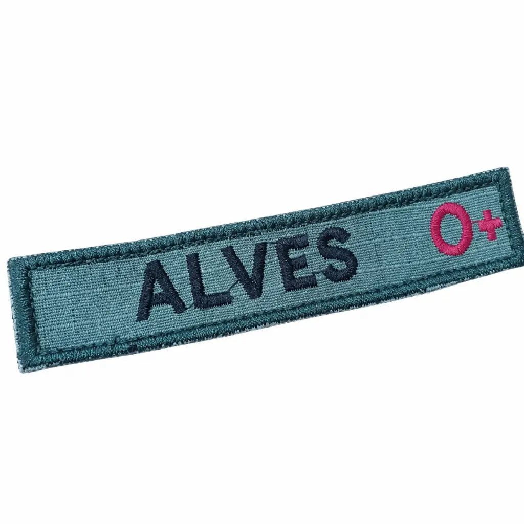 Distintivo retangular azul-escuro com ALVES bordado e O+ rosa