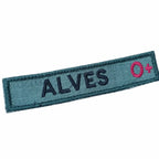 Distintivo retangular azul-escuro com ALVES bordado e O+ rosa