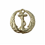 Emblema circular dourado com âncora central e folhas entrelaçadas, laço superior