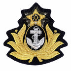 Emblema bordado preto com âncora prateada, folhas douradas, estrela dourada e contorno irregular