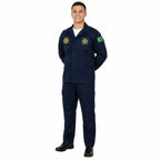 Jovem militar azul-marinho com patch da Bandeira do Brasil, mãos atrás, sorriso, fundo branco