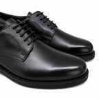 Par de sapatos sociais pretos em couro liso com cadarços e ponta alongada
