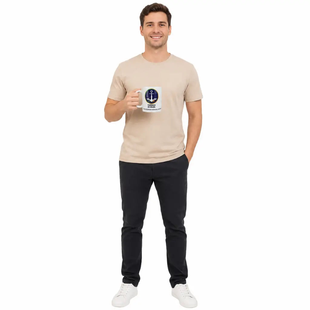 Homem sorridente em estúdio com camiseta bege segurando Caneca Marinha do Brasil com âncora azul