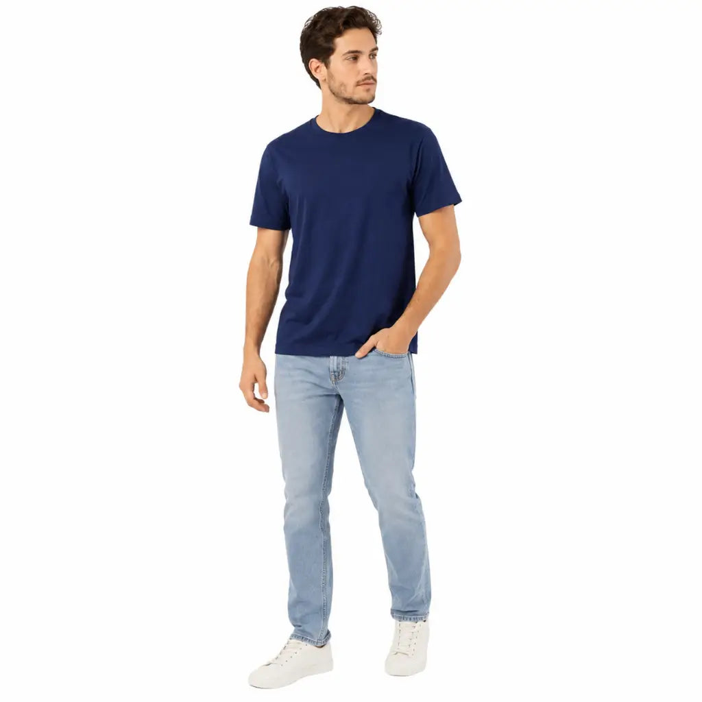 Camiseta Algodão Azul Noite Marinha azul com jeans claro e tênis branco em pose casual