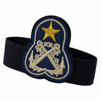 Distintivo azul escuro com estrela dourada e âncoras prateadas, preso por faixa elástica preta