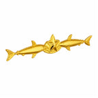 Broche dourado com estrela central entre dois peixes simétricos