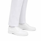 Sapatos brancos com cadarços, sobre calças brancas, visual minimalista