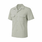 Camisa verde claro de manga curta, dois bolsos com abas e fechamento por botões.