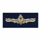 Distintivo retangular azul escuro com emblema bege e âncora