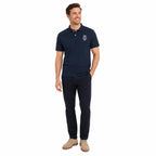 Homem sorridente com Camisa Polo Azul Marinha Bordada e emblema circular coroado