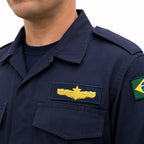 Gola azul, insígnia amarela de aviação à esquerda e bandeira do Brasil à direita.