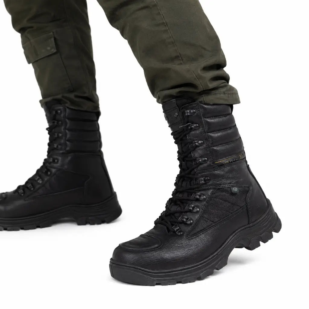 Coturno Militar Azimute Preto: close-up de botas pretas com cadarços e solado tracionado, com calça oliva
