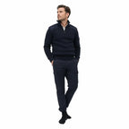 Homem em pulôver azul-marinho com meias escuras, fundo branco