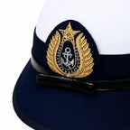 Boné naval branco com aba azul-marinho e insígnia dourada com âncora
