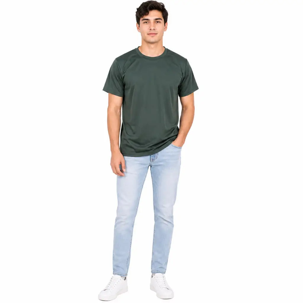 Modelo masculino em pé com Camiseta Poliéster Verde Militar verde lisa, jeans claros e tênis branco