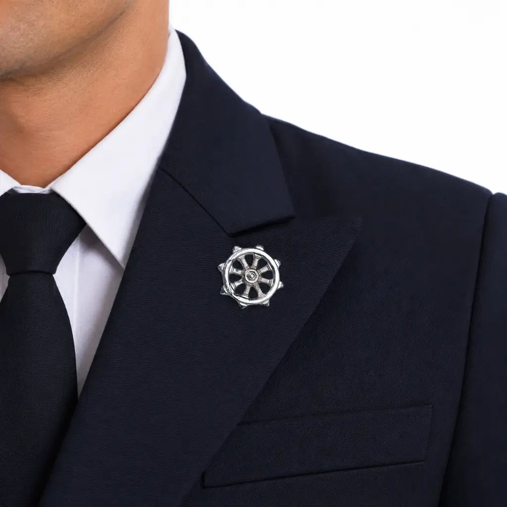 Homem com paletó azul marinho e broche prata em leme no peito esquerdo