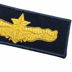 Distintivo bordado em azul-marinho, asa estilizada com estrela dourada