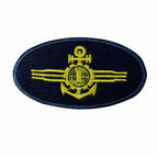 Emblema oval azul marinho com âncora, globo e asas amarelas